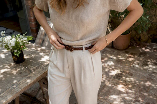 Woman adjusting belt on linen pants